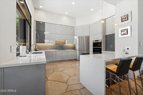 a living room with stainless steel appliances kitchen island granite countertop furniture and a refrigerator