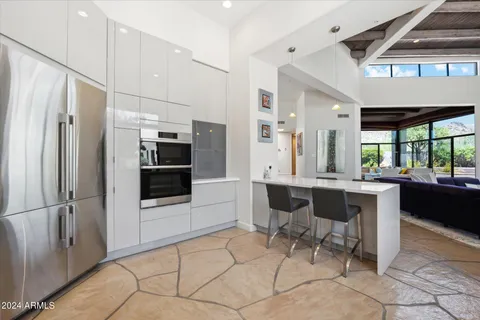 a kitchen with stainless steel appliances kitchen island granite countertop a refrigerator and a sink