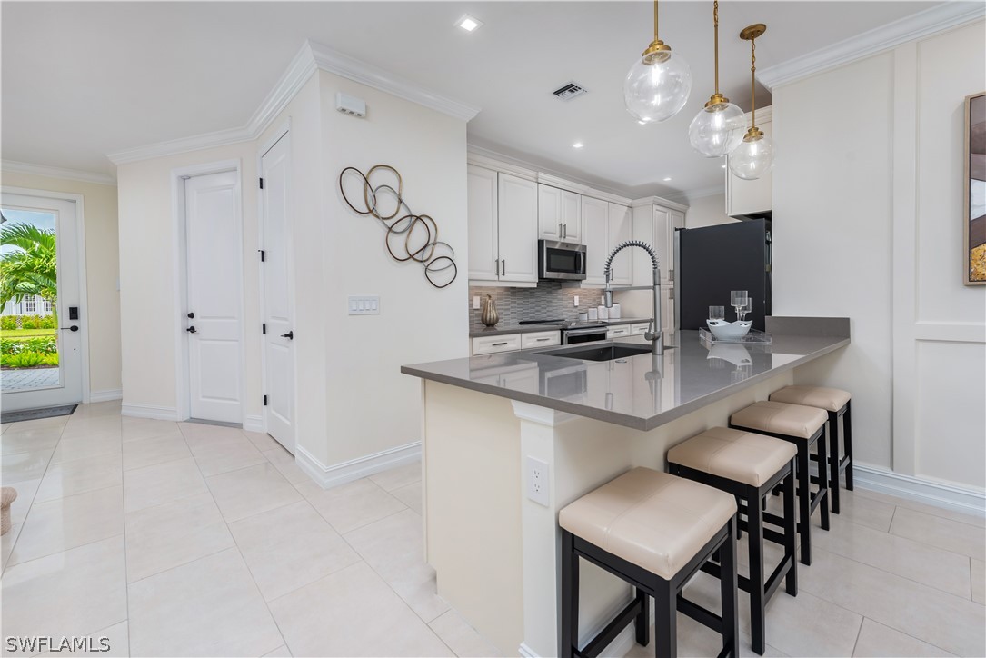 7341 Rockefeller Drive Naples, FL 34119 - Photo 13 of 34 a kitchen with stainless steel appliances granite countertop a sink a stove and a refrigerator