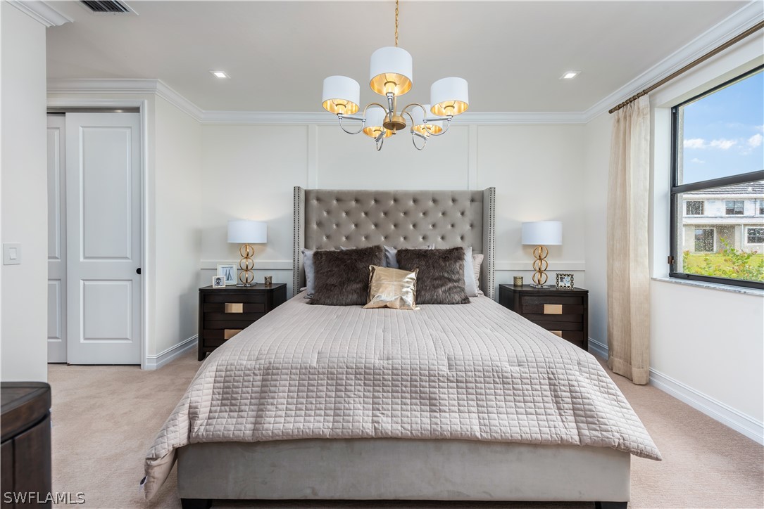 7341 Rockefeller Drive Naples, FL 34119 - Photo 16 of 34 a bedroom with a bed and chandelier