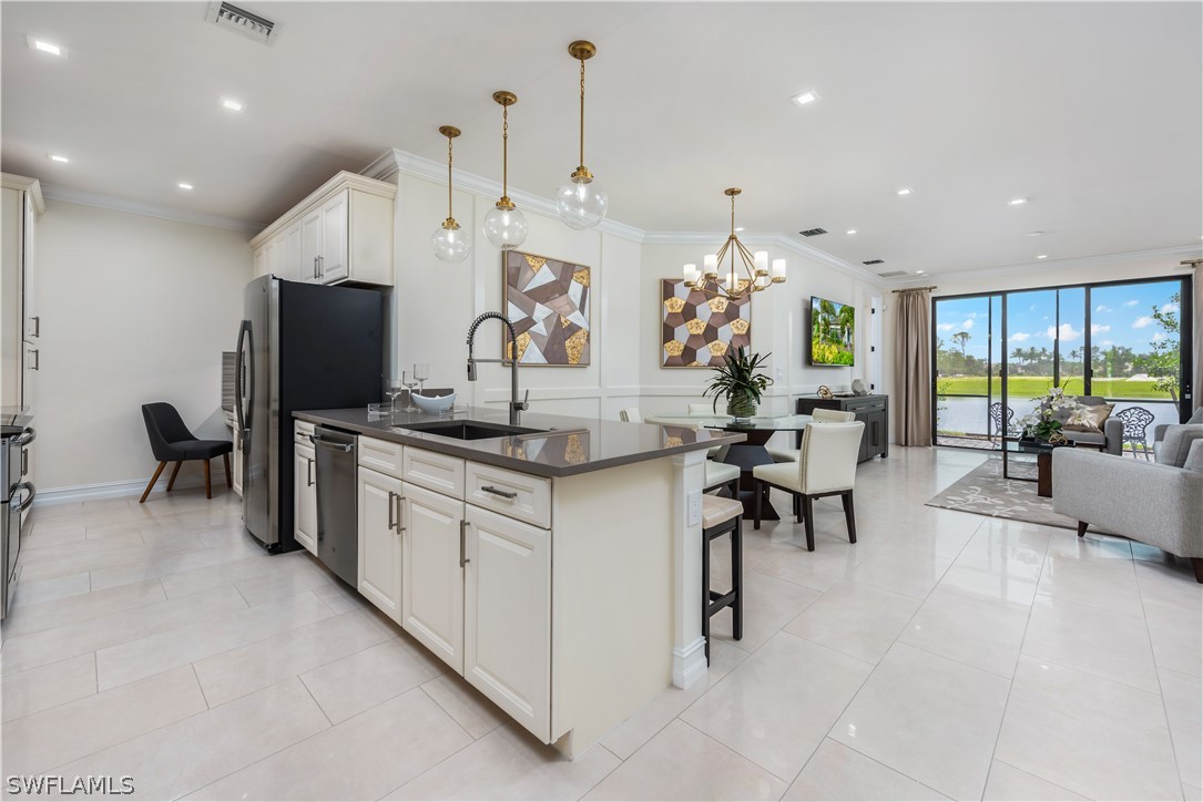 7341 Rockefeller Drive Naples, FL 34119 - Photo 28 of 34 a kitchen with stainless steel appliances granite countertop sink stove and refrigerator