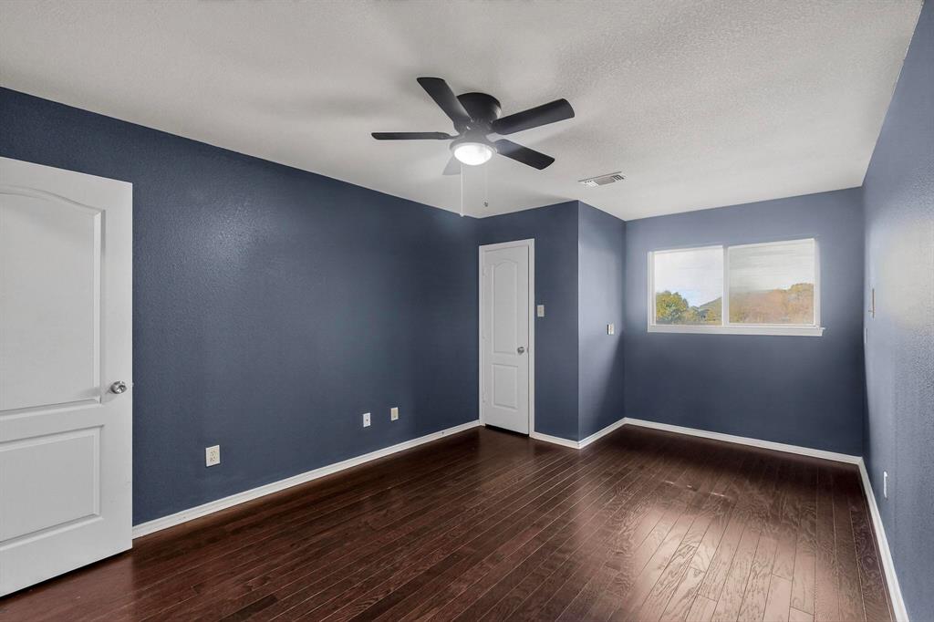 1121 Reedsport Place DeSoto, TX 75115 - Photo 25 of 40 a view of an empty room with wooden floor and a ceiling fan