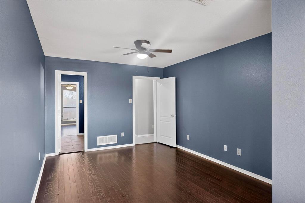 1121 Reedsport Place DeSoto, TX 75115 - Photo 26 of 40 a view of an empty room with wooden floor and a ceiling fan
