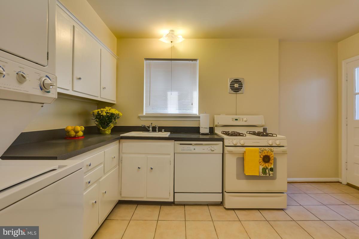 407 Royalton Road Silver Spring, MD 20901 - Photo 14 of 30 a kitchen with granite countertop white cabinets and white appliances