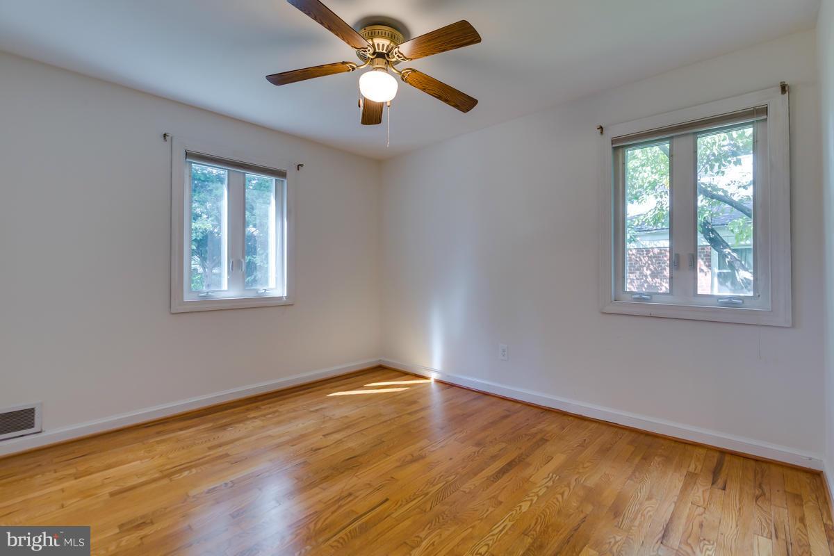 407 Royalton Road Silver Spring, MD 20901 - Photo 9 of 30 a view of an empty room with wooden floor and a window