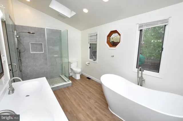 a bathroom with a tub sink and mirror