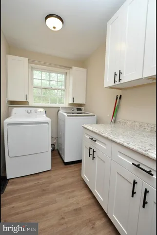 a kitchen with sink a stove and white cabinets