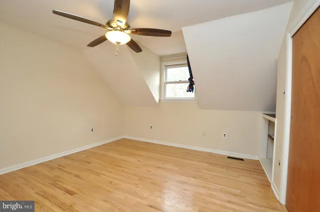 an empty room with a window and a ceiling fan