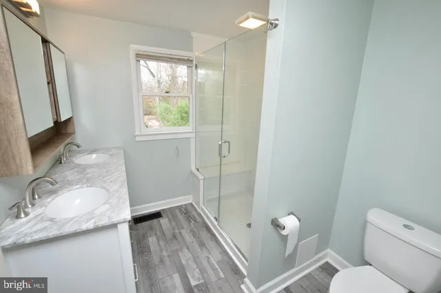 a bathroom with a granite countertop sink toilet and shower