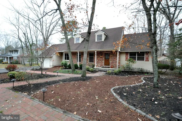 a front view of a house with yard tree and outdoor seating