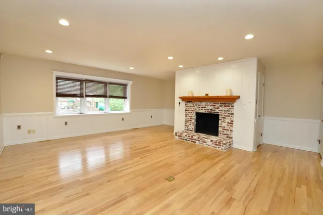 a view of empty room with wooden floor and fireplace