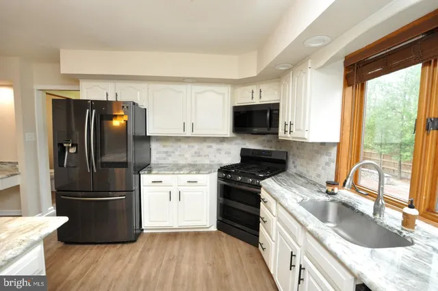 a kitchen with a refrigerator stove and sink