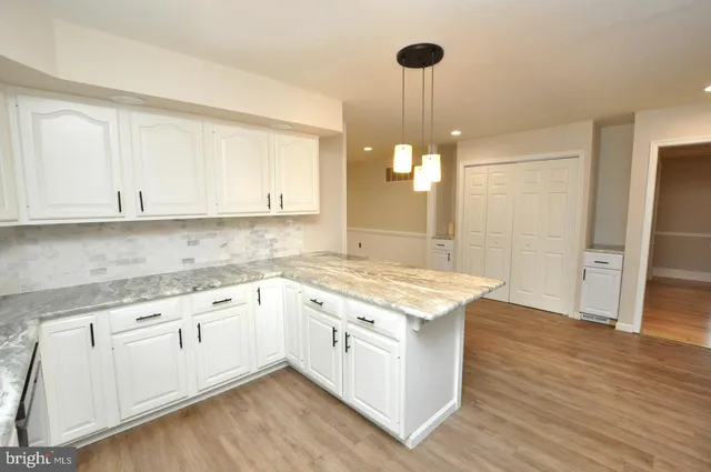 a kitchen with granite countertop white cabinets and white appliances