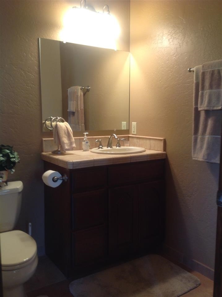 1092 South Hunters Run Show Low, AZ 85901 - Photo 33 of 36 a bathroom with a toilet sink and mirror
