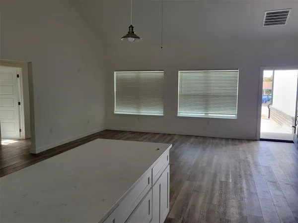 a view of a kitchen with wooden floor and electronic appliances