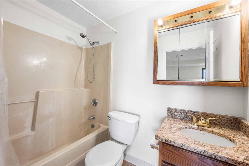 39 Parlin Street, Unit 503 Everett, MA 02149 - Photo 18 of 24 a bathroom with a granite countertop sink toilet and shower