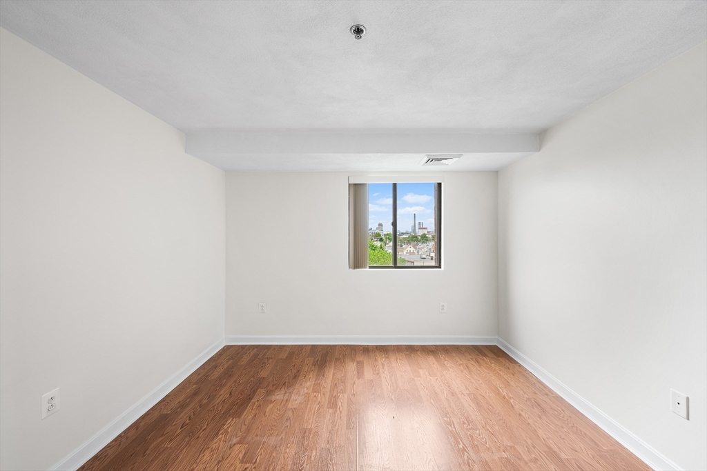 39 Parlin Street, Unit 503 Everett, MA 02149 - Photo 22 of 24 a view of an empty room with a window and wooden floor