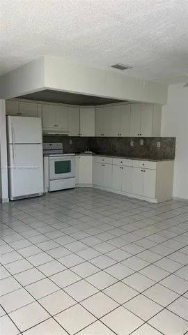a kitchen with granite countertop white cabinets and stainless steel appliances