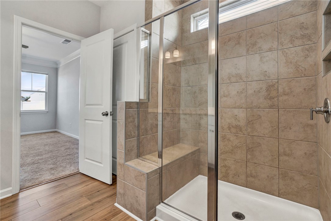 270 Pendergast Road Greenville, SC 29605 - Photo 19 of 43 Step into a tiled shower with a convenient built-in bench, offering a luxurious and functional bathing experience.