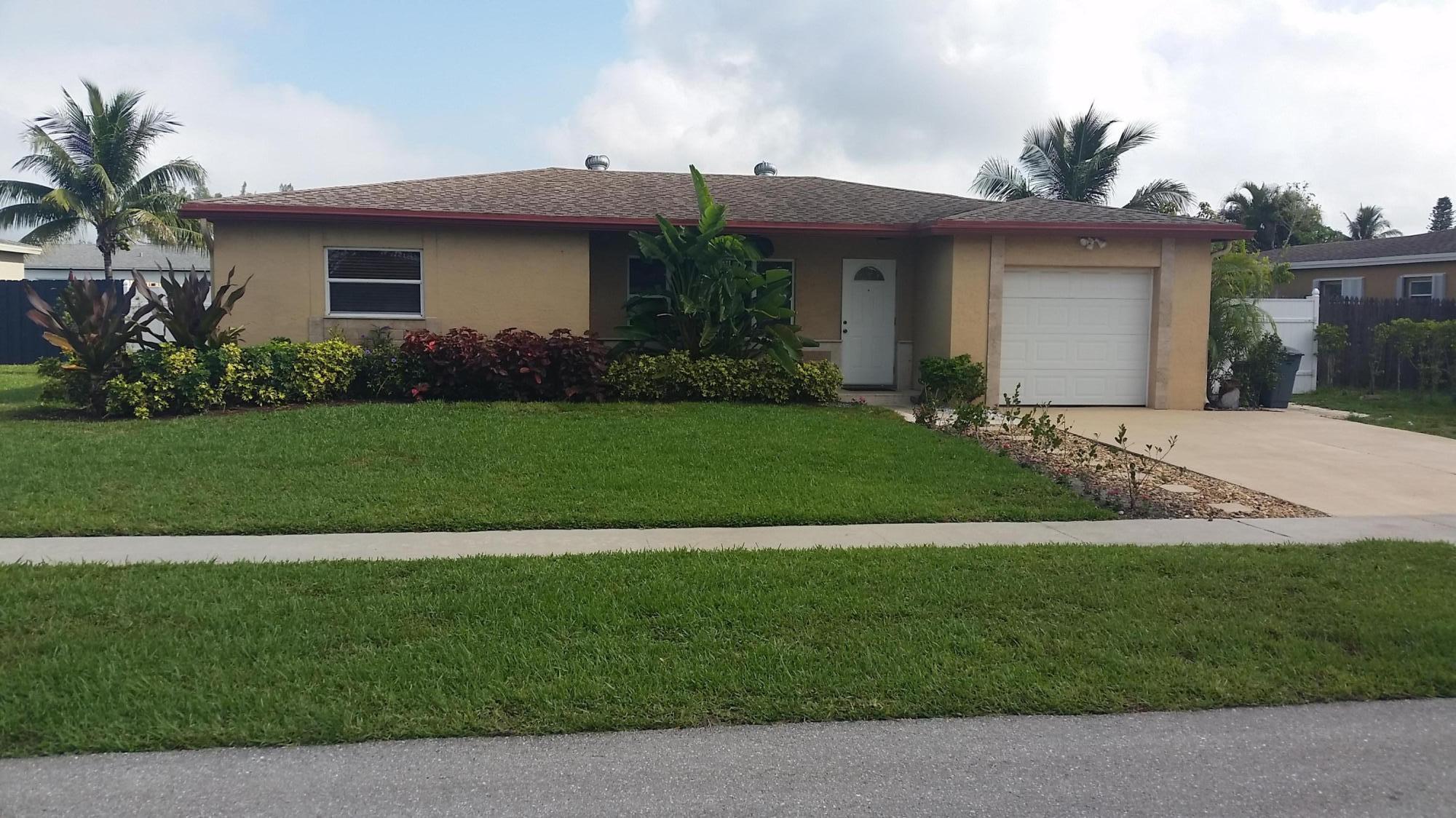 4693 Bison Street Boca Raton, FL 33428 - Photo 1 of 34 a front view of a house with a garden