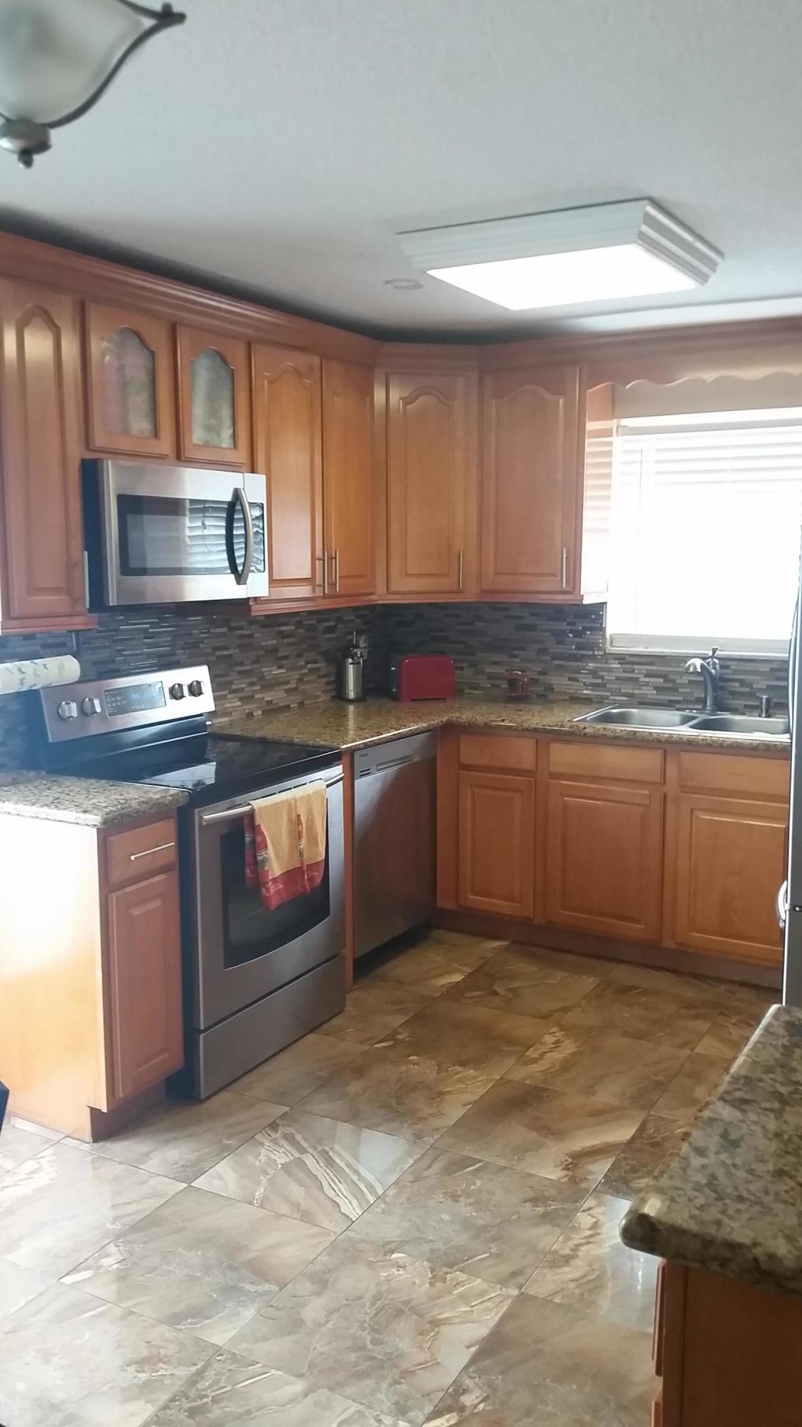 4693 Bison Street Boca Raton, FL 33428 - Photo 11 of 34 a kitchen with stainless steel appliances granite countertop a sink stove and cabinets