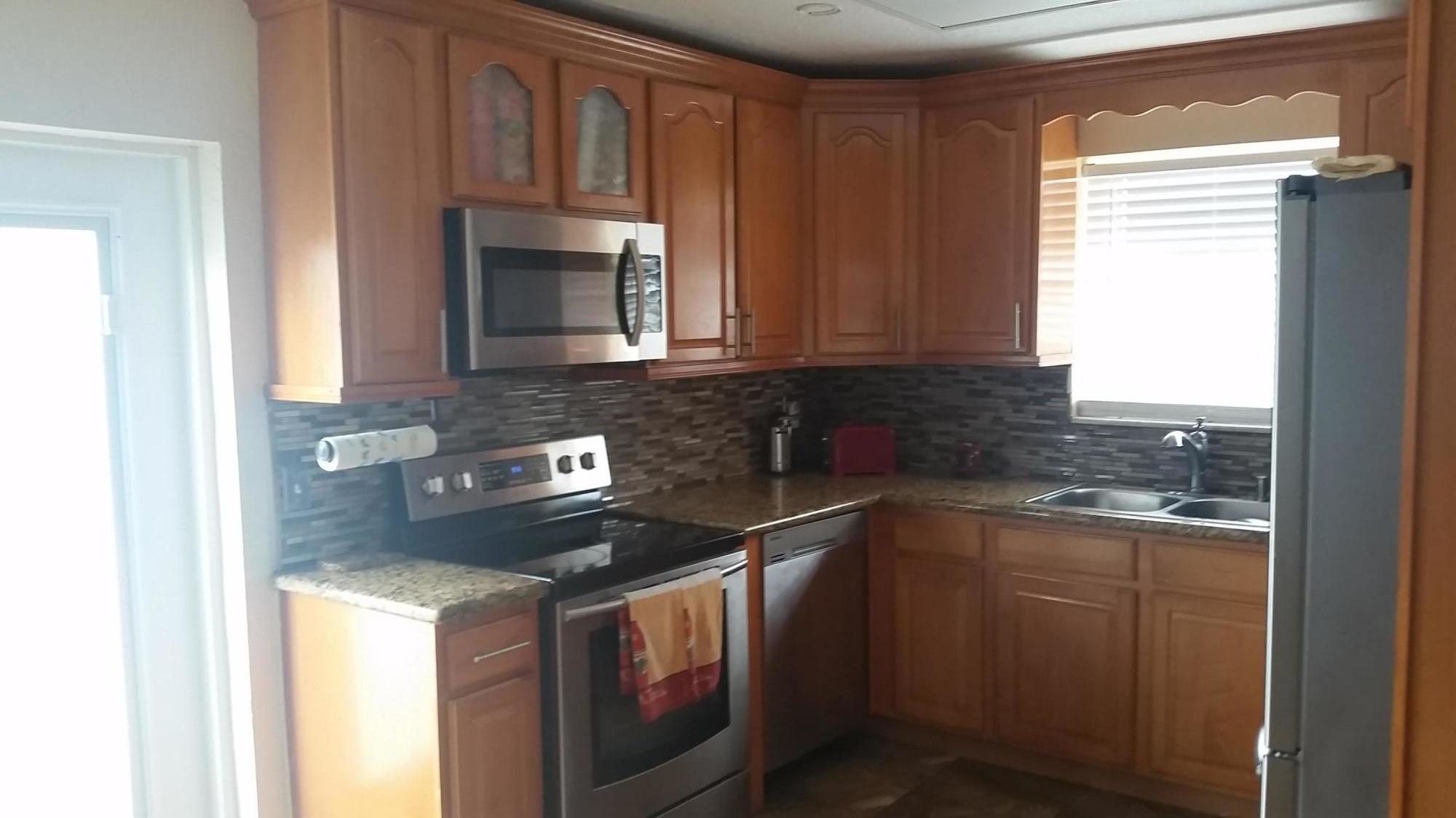 4693 Bison Street Boca Raton, FL 33428 - Photo 13 of 34 a kitchen with stainless steel appliances granite countertop a sink stove and cabinets
