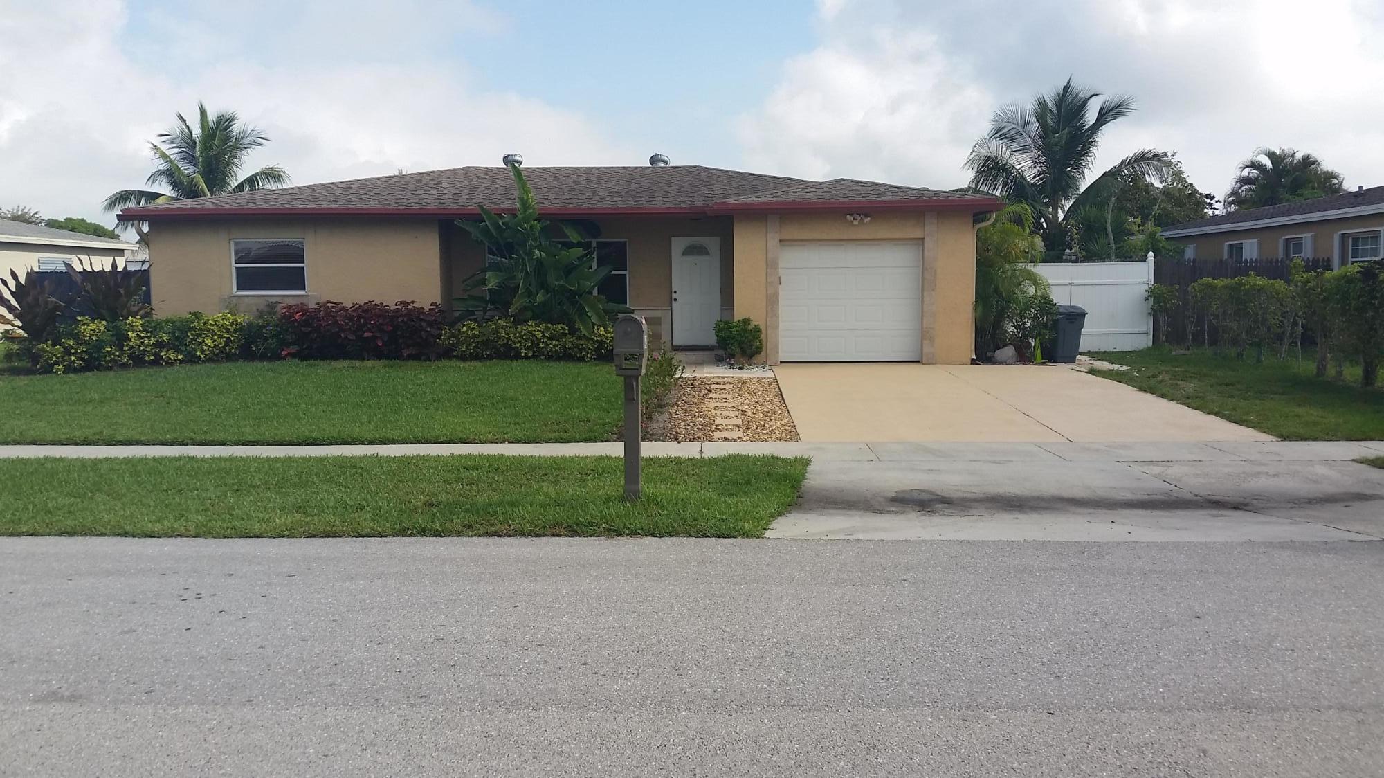 4693 Bison Street Boca Raton, FL 33428 - Photo 2 of 34 a front view of a house with a yard and garage