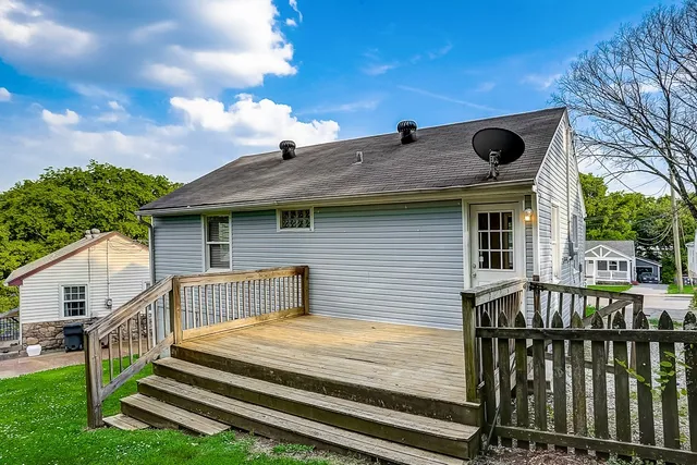 a view of a house with wooden deck and a backyard