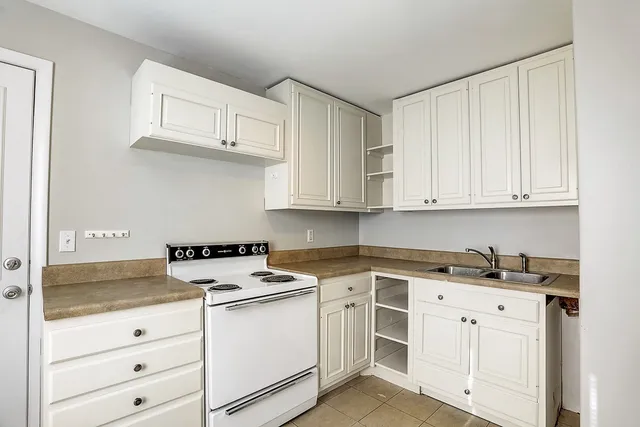 a kitchen with granite countertop white cabinets and a sink