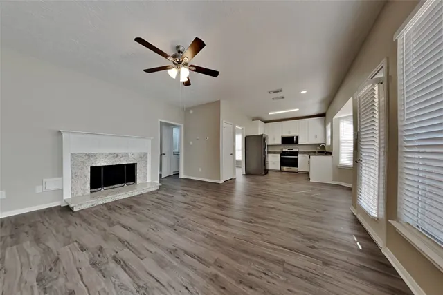 a view of a kitchen and an empty room with a fireplace