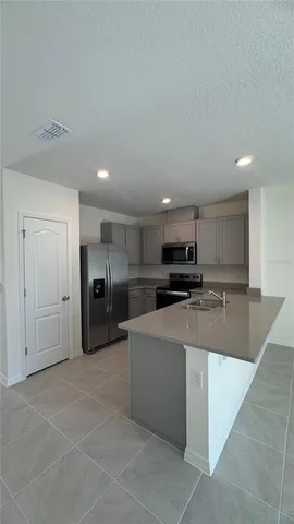 a large kitchen with a large counter top stainless steel appliances and cabinets