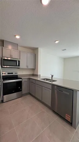 a kitchen with stainless steel appliances granite countertop a sink and dishwasher a refrigerator with white cabinets