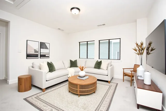 a spacious bedroom with a bed a couch and a chandelier