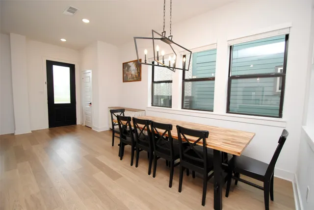 a large kitchen with a large counter top a sink stainless steel appliances and cabinets