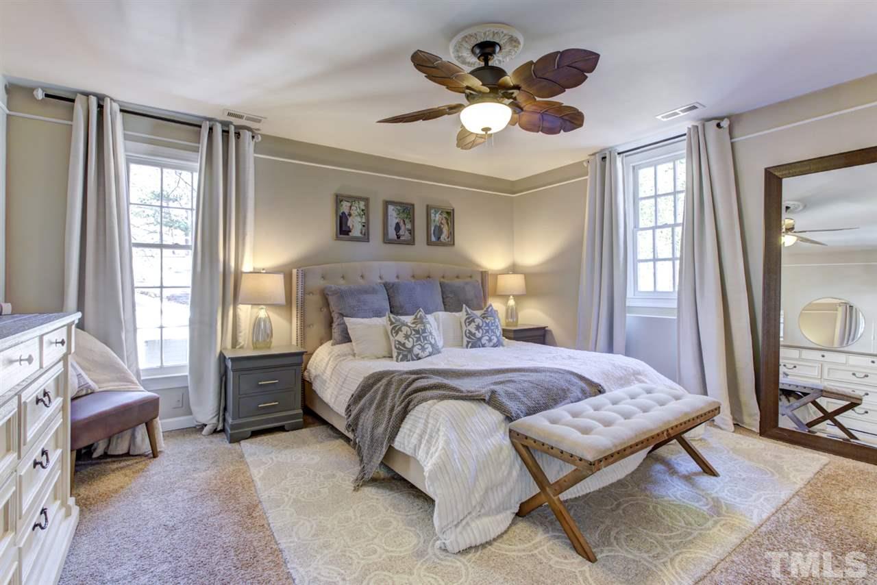 4417 Lancashire Drive Raleigh, NC 27613 - Photo 13 of 30 a bedroom with a large bed and a chandelier