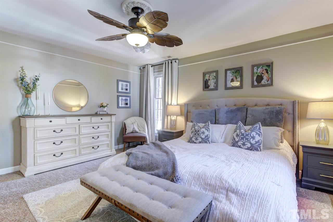4417 Lancashire Drive Raleigh, NC 27613 - Photo 14 of 30 a bedroom with a bed a lamp and a dresser