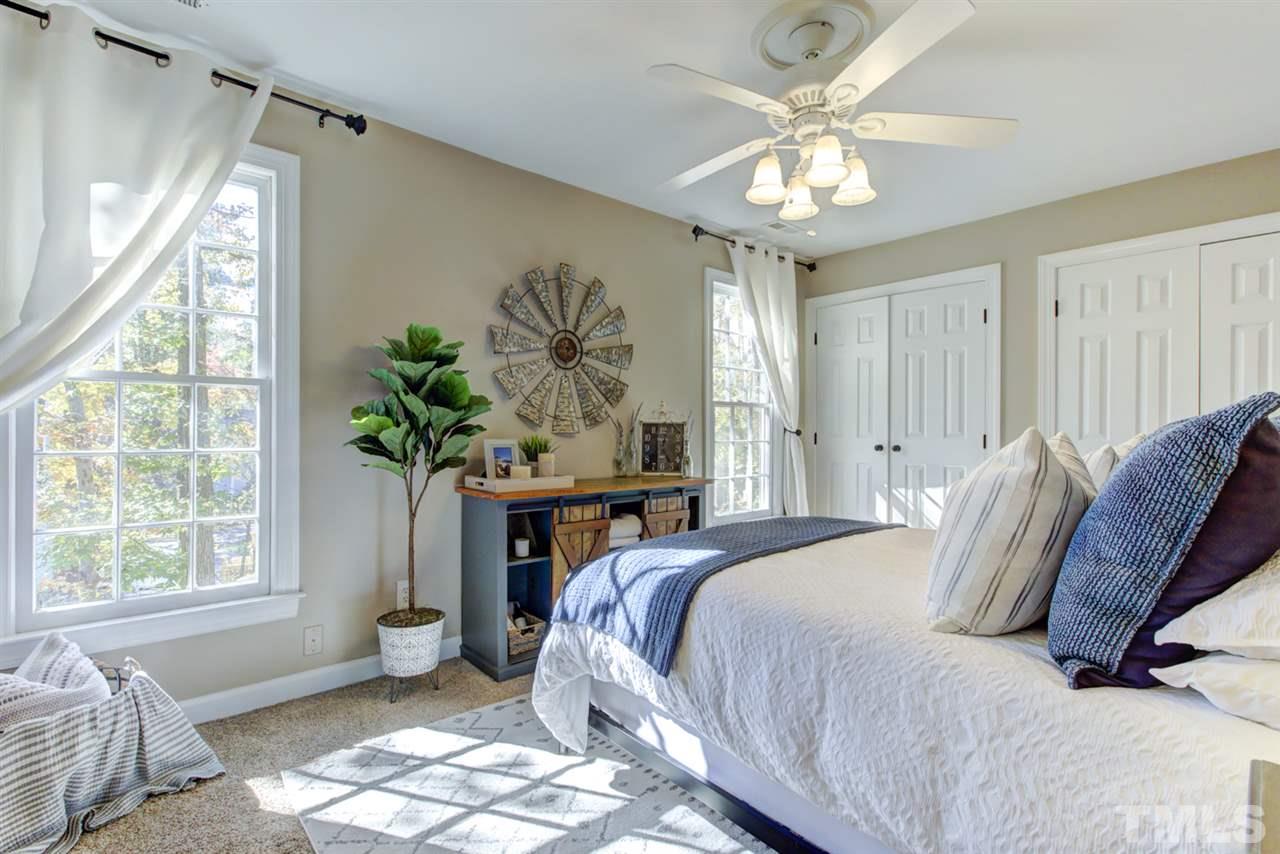 4417 Lancashire Drive Raleigh, NC 27613 - Photo 17 of 30 a spacious bedroom with a bed and a chandelier