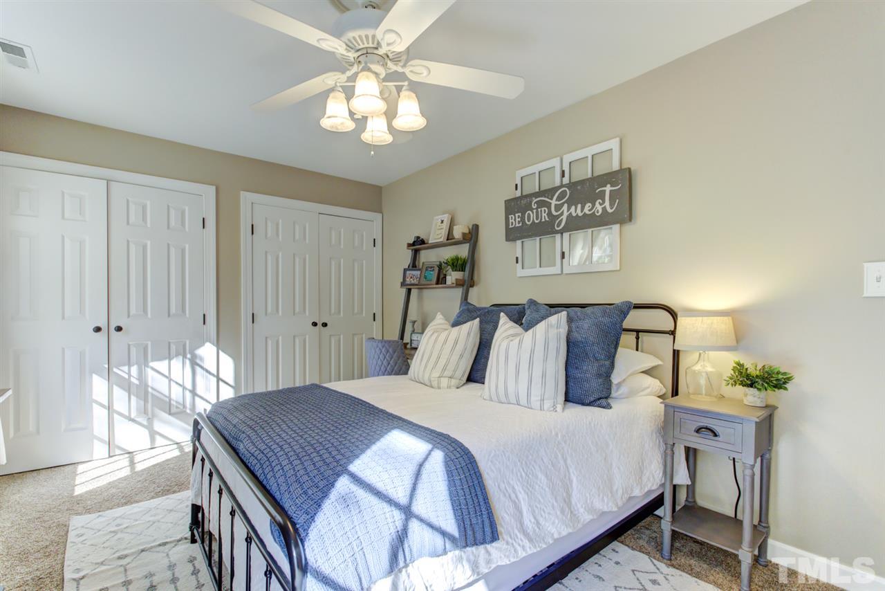 4417 Lancashire Drive Raleigh, NC 27613 - Photo 18 of 30 a bedroom with a bed and a chandelier