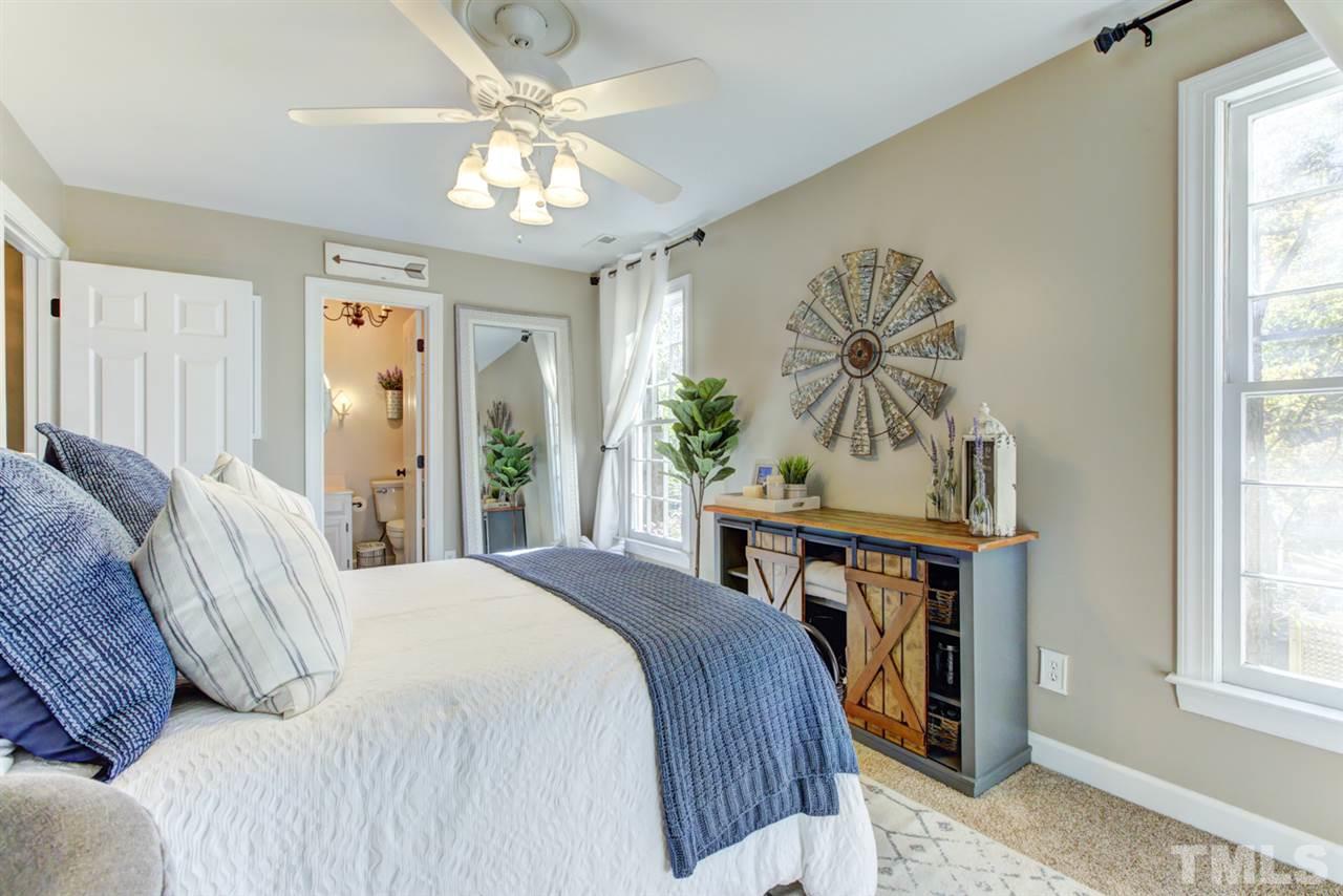 4417 Lancashire Drive Raleigh, NC 27613 - Photo 19 of 30 a bedroom with a bed and a chandelier