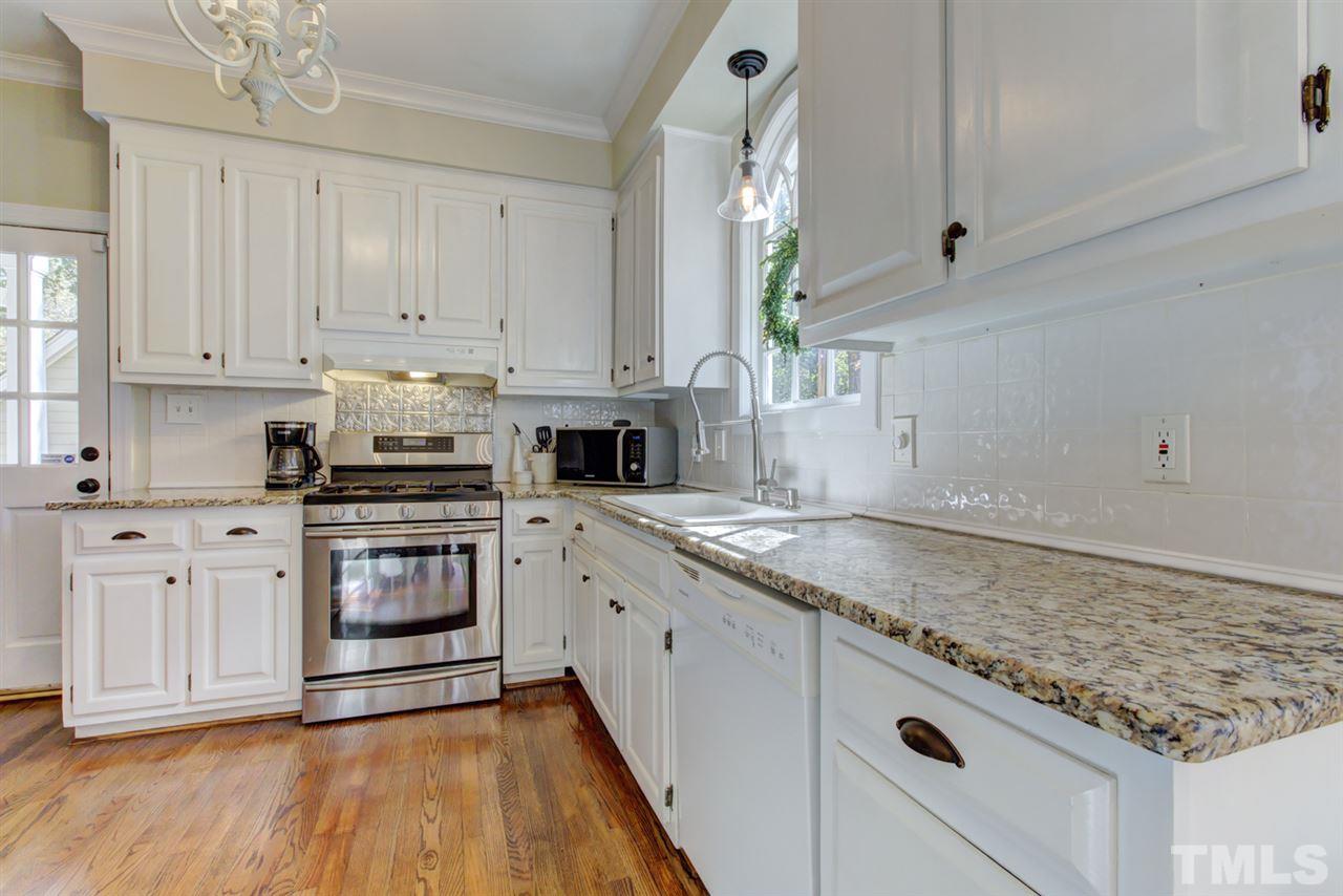 4417 Lancashire Drive Raleigh, NC 27613 - Photo 4 of 30 a kitchen with granite countertop white cabinets and white appliances