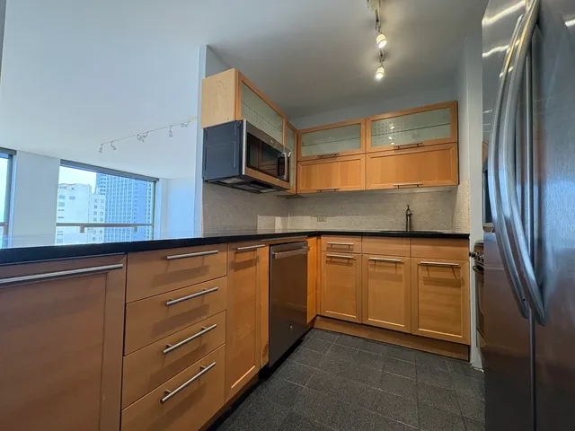 a kitchen with stainless steel appliances granite countertop a refrigerator and a stove