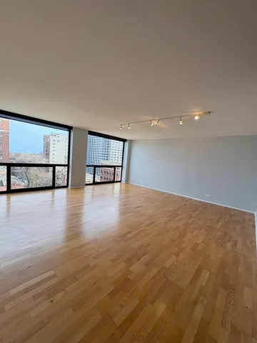 a view of empty room with wooden floor