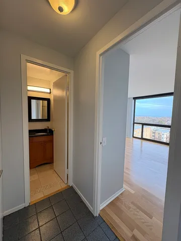 a view of a hallway view with wooden floor and kitchen