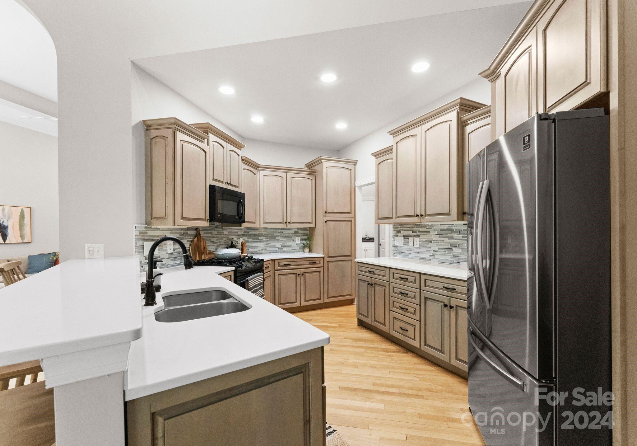 687 Normandy Road Mooresville, NC 28117 - Photo 15 of 32 a kitchen with a sink a refrigerator and a stove top oven