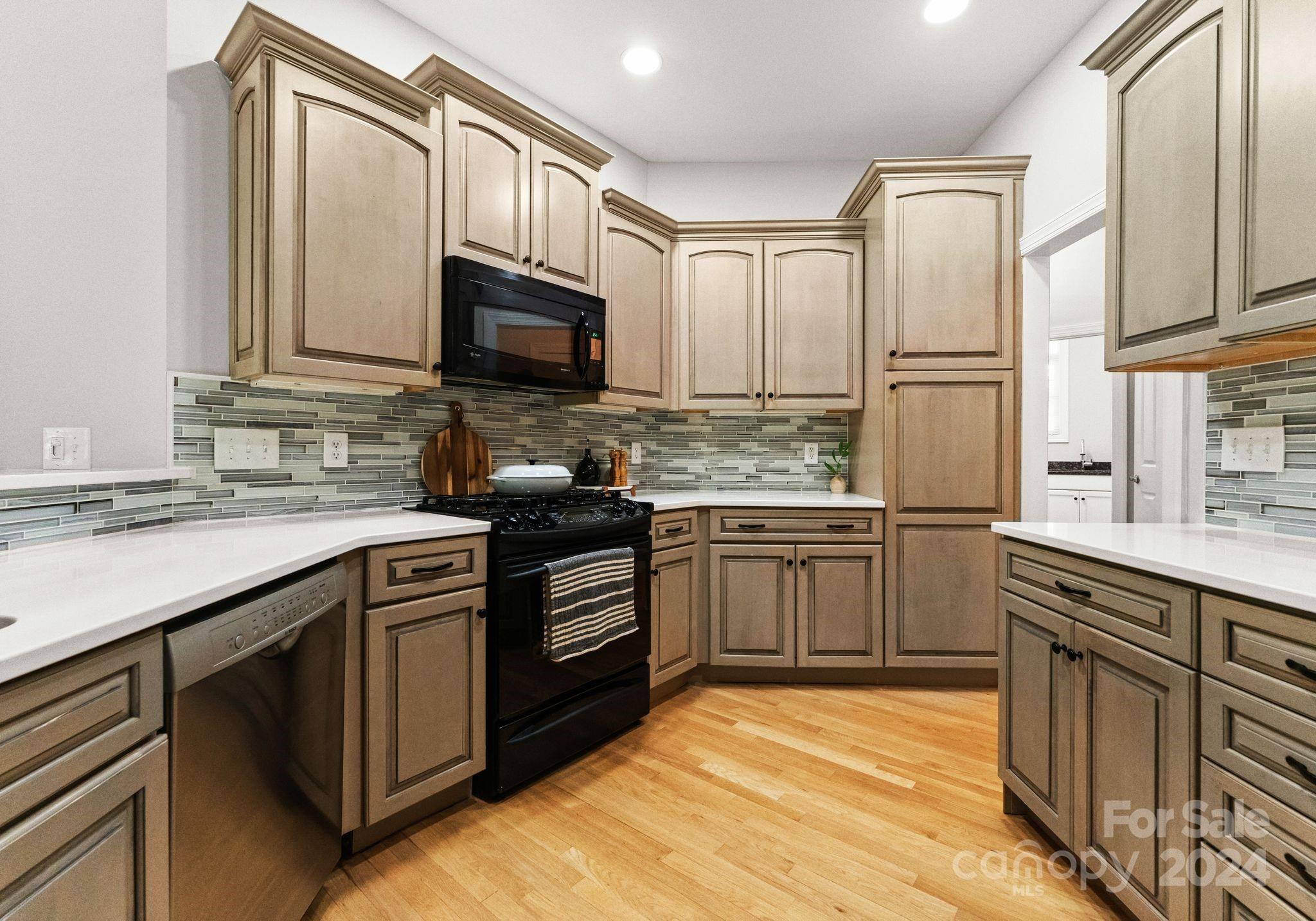 687 Normandy Road Mooresville, NC 28117 - Photo 17 of 32 a kitchen with stainless steel appliances granite countertop a stove top oven a sink dishwasher a refrigerator and cabinets with wooden floor