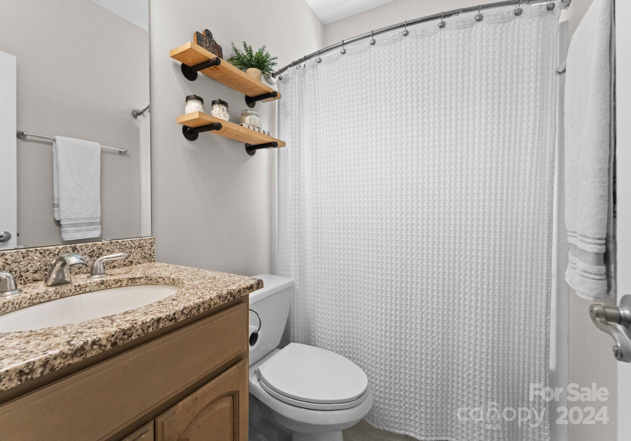 687 Normandy Road Mooresville, NC 28117 - Photo 27 of 32 a bathroom with a granite countertop sink a toilet and a mirror