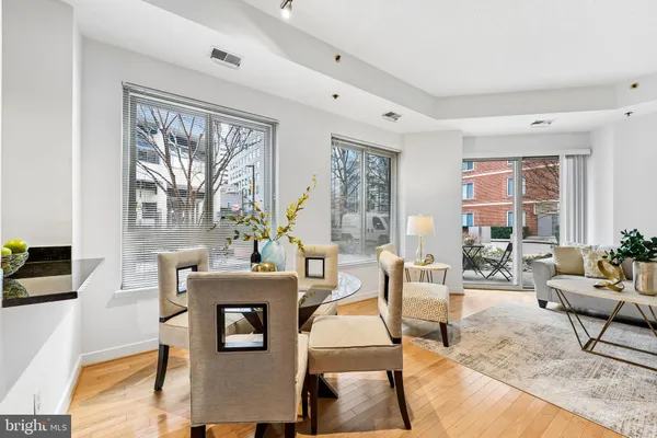 a living room with furniture a table and large windows