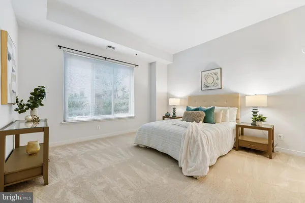 a bedroom with a bed and a potted plant next to a window