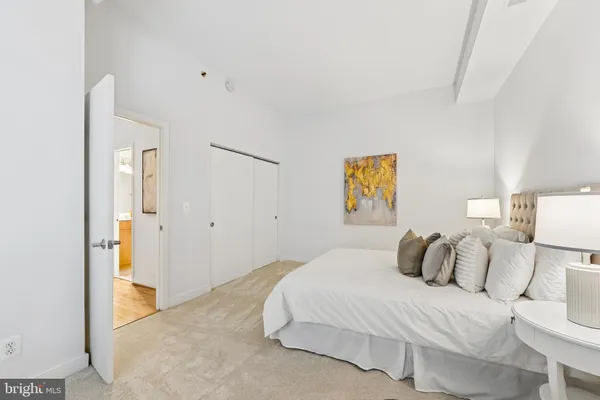 a bedroom with a bed and a painting on the wall