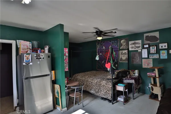 a bedroom with furniture a ceiling fan and a window